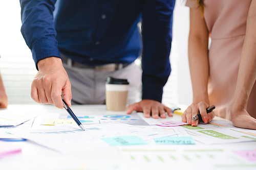 Employee business man give flip chart presentation to smiling colleagues at negotiations, workers laugh at office meeting, man present project or idea to happy coworkers at briefing