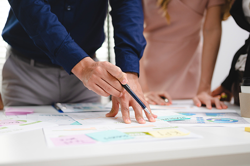 Group of young Asian and multiethnic business man and business woman standing while having a friendly conversation and discussion during break time in modern office