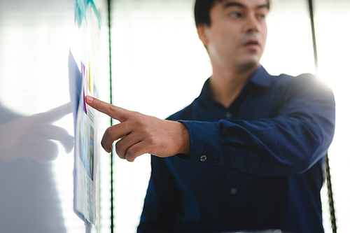 Employee business man give flip chart presentation to smiling colleagues at negotiations, workers laugh at office meeting, man present project or idea to happy coworkers at briefing