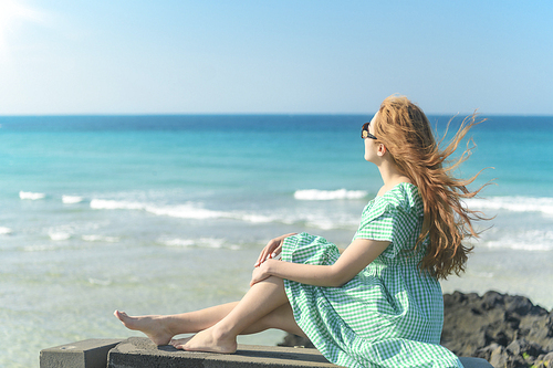 제주도 함덕해변의 벤치에 앉아 있는 젊은여성