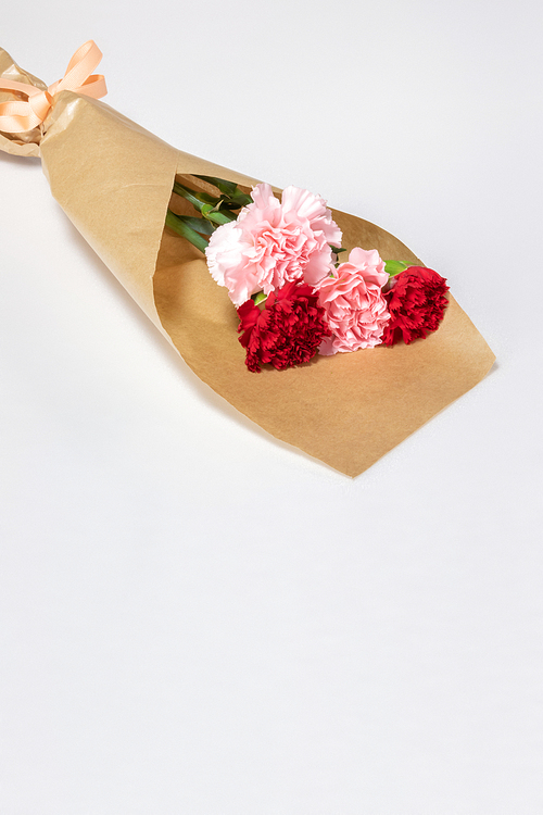 흰 바닥에 놓여져 있는 카네이션 꽃다발. 빨간색, 연분홍색