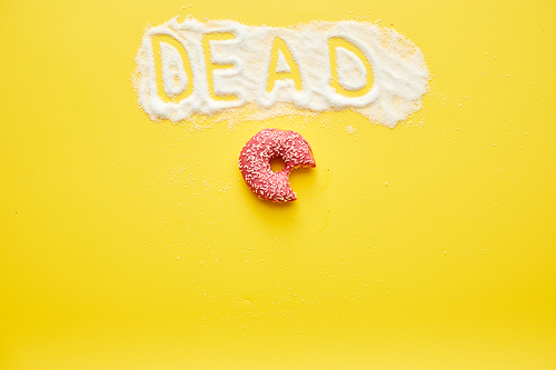 Half-eaten tasty doughnut with topping and dead word written on sugar powder, yellow background