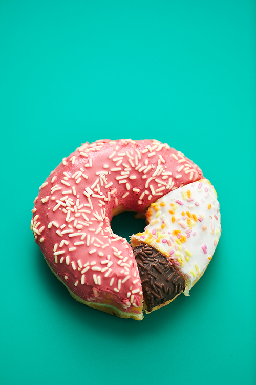 Close-up of tree types of doughnut slices joining to each other on green background