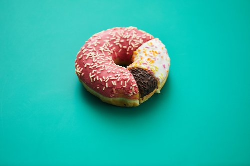 Close-up of sweet pie chart made of various doughnuts with toppings and sprinkles on green background