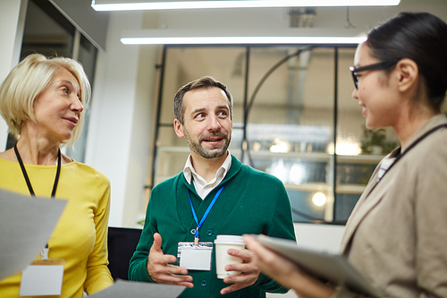 Content confident business colleagues discussing development strategy while drinking coffee after conference