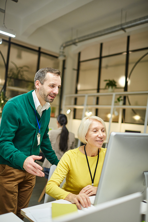 Cheerful graphic designers in casual clothing working on new project and discussing web design