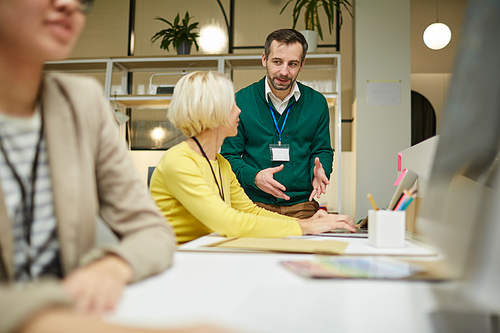 Confident enterprising colleagues in casual clothing discussing ideas while working on new project