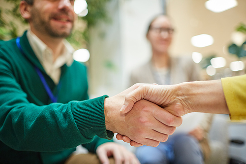 Conference participant shaking hand of female speaker