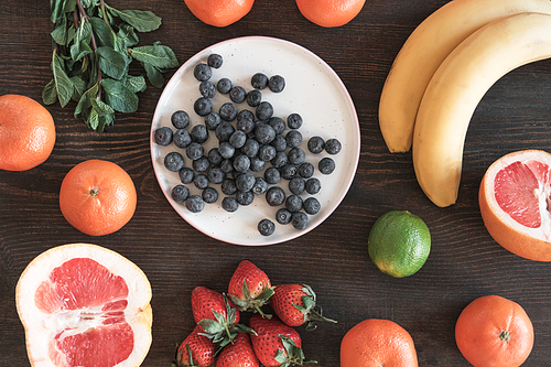 Directly above view of delicious ingredients such as grapefruit, strawberry, blueberry and bananas prepared for fruit smoothie