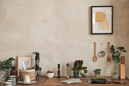 Cozy interior of kitchen with abstract picture and utensils in wall, kitchen devices and crockery on counter