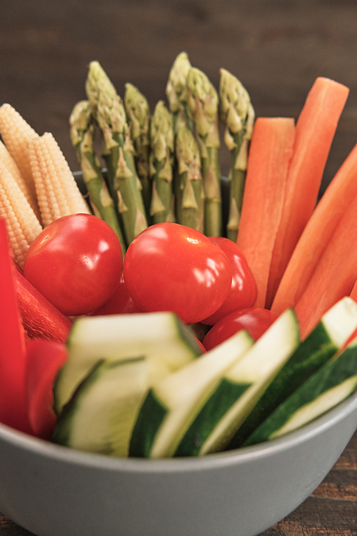 Close-up of vegetable slices such as carrot, bell pepper, asparagus, corn, tomato and cucumber in bowl