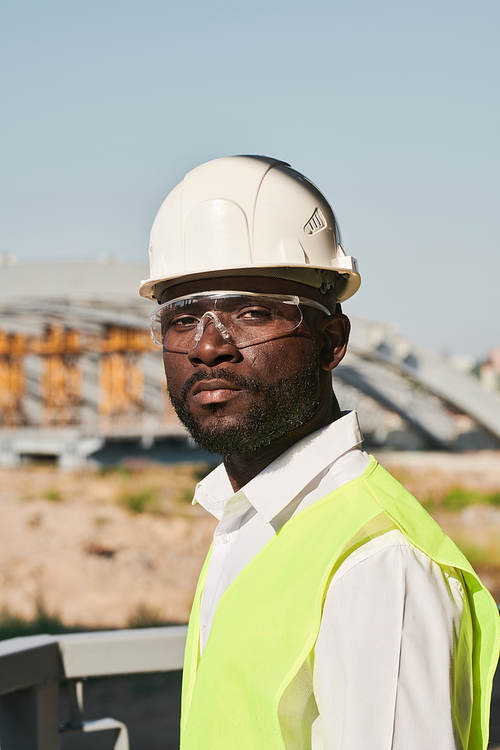 Portrait of young male engineer posing at construction site