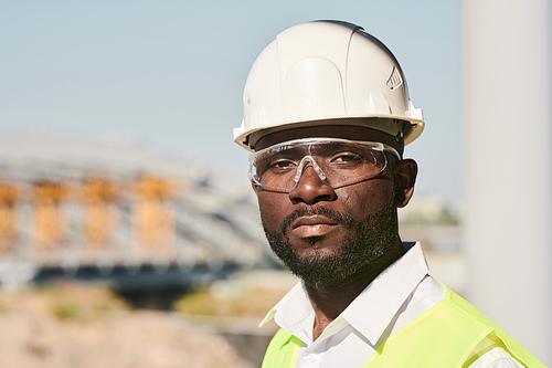 Portrait of young male engineer posing at construction site