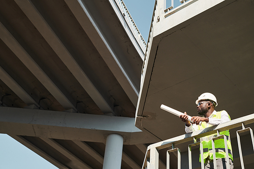 Construction engineer wearing safety vest and work helmets standing at balcony in construction site