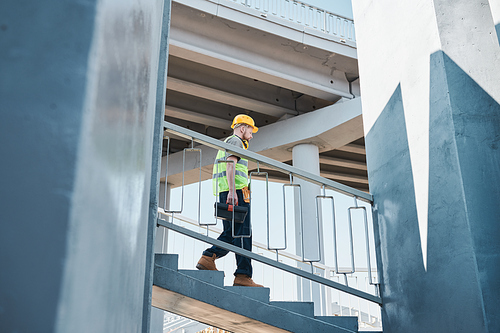 Wide angle view at builder standing in unfinished apartment building on construction site, copy space