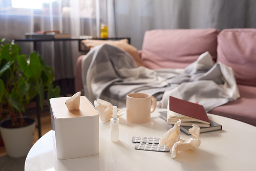 Horizontal no people shot of paper napkins, pills, meds, cup of tea and book on table in living room