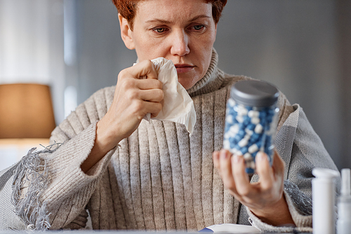 Portrait shot of mature Caucasian woman sitting at desk in front of laptop having online appointment with doctor