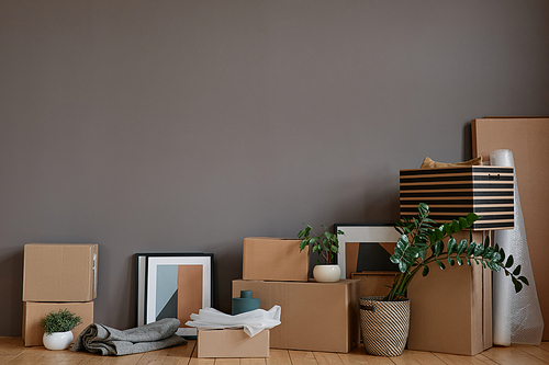 Horizontal no people shot of unpacked boxes and various stuff placed in loft room against gray wall