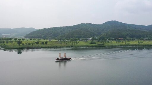경상북도 의성 낙단보에서 출발한 돛단배 율정호가 낙동강 수면을 빠르게 항해하는 항공 촬영 영상