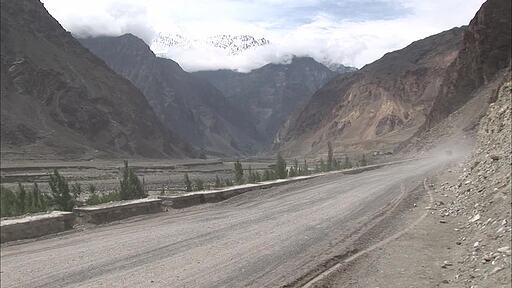 파키스탄 기르기트에서 히말라야로 향하는 비포장 도로를 먼지를 날리면 지나가는 버스와 트럭