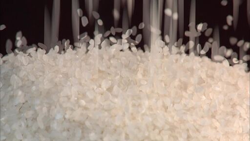 수많은 하얀색 쌀알이 위에서 떨어져서 대나무 광주리에 떨어져서 쌓이는