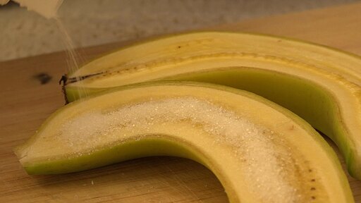 반으로 자른 바나나 위에 설탕가루를 뿌린 후 토치로 지글지글 녹여 만든 바나나 브륄레
