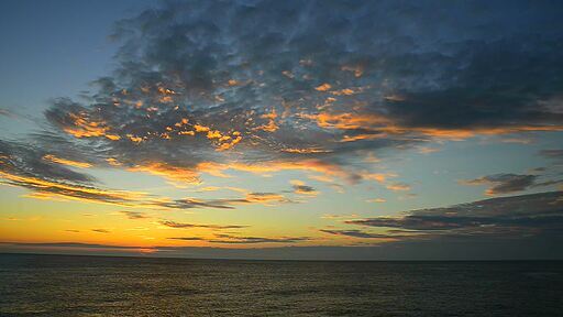 해질 녘 붉은 노을과 구름이 아름다운 넓은 바다와 하늘 풍경