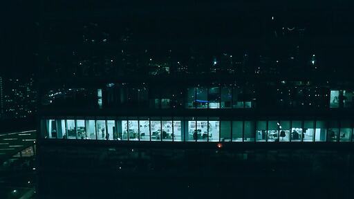 반짝이는 유리건물에 비치는 서울 야경과 건물 내부의 불 빛
