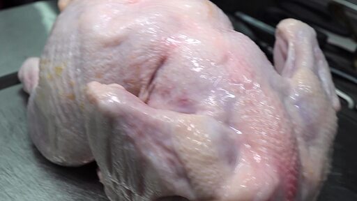 생 닭의 뼈를 발골하고 살을 발라내어 통 순살 닭고기를 만드는 전문가의 손