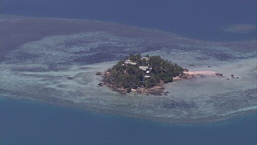 맑고 푸른 태평양 섬 주변에 산호초 군락이 넓게 펼쳐진 항공 촬영 영상