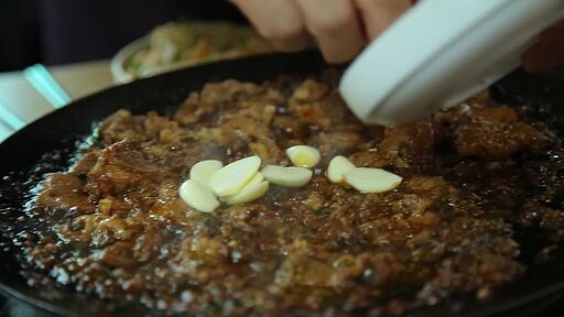 한국음식 양념 졸임 돼지갈비를 생마늘을 올리고 함께 굽는
