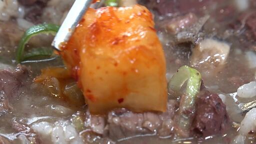 소 한마리 국밥 한 숟가락에 깍두기를 얹어 먹는 모습