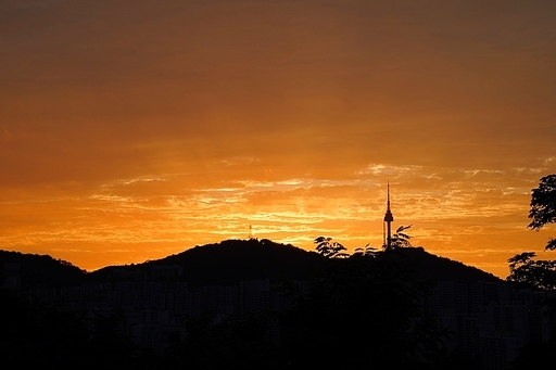 황금빛 노을이 진 서울하늘로 멀리 남산타워가 실루엣으로 보이는 응봉산 야경입니다.
