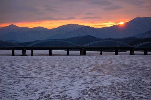 얼어버린 북한강 위로 일몰이 내리는 사진입니다.