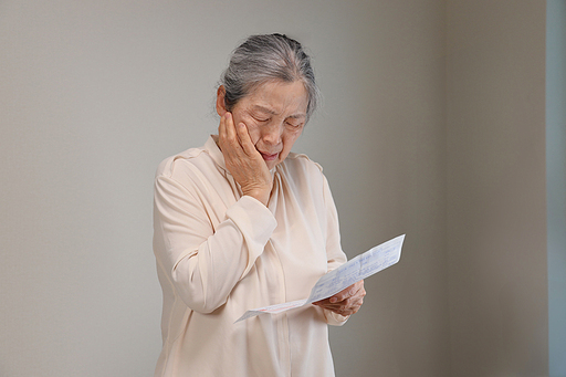 종이를 들고 걱정하는 노인 여성